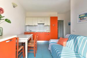 una cucina con armadi arancioni, tavolo e divano di Casa Mambrino Panorama a Cavo