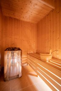 a sauna with a tub and a wooden wall at Perła Bałtyku in Świnoujście