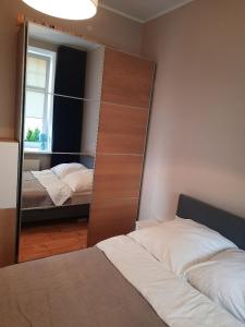 シフィノウイシチェにあるApartament Nowowiejskiegoのベッドルーム1室(ベッド2台、鏡付)