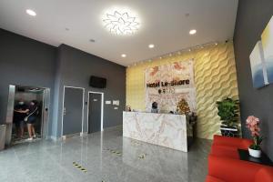 a lobby with a counter and a yellow wall at Hotel Le-Shore in Kuala Selangor