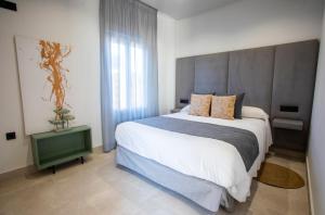 a bedroom with a large bed and a large window at ON City Apartments in Matalascañas