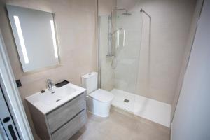 a bathroom with a toilet and a shower and a sink at ON City Apartments in Matalascañas