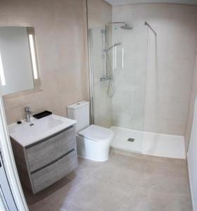 a bathroom with a shower and a toilet and a sink at ON City Apartments in Matalascañas