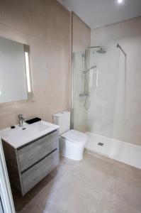 a bathroom with a shower and a toilet and a sink at ON City Apartments in Matalascañas