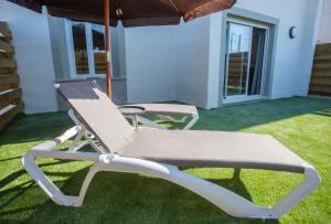 a lounge chair and an umbrella in a yard at ON City Apartments in Matalascañas
