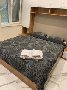 a bedroom with a bed with two towels on it at Патилови in Sandanski
