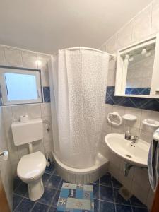 a bathroom with a white toilet and a sink at Apartments LucMar in Vir