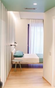 una camera con letto, tavolo e finestra di Vietti Apartments a Castiglione Falletto