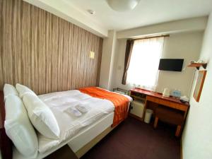 ein Hotelzimmer mit einem Bett und einem Schreibtisch in der Unterkunft Web Hotel Tokyo Asakusabashi in Tokio