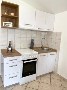 una cocina con armarios blancos y fregadero en Apartments LucMar, en Vir