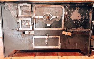 an old metal stove sitting on top of a floor at QUINTA DO CAMBEIRO in Viana do Castelo