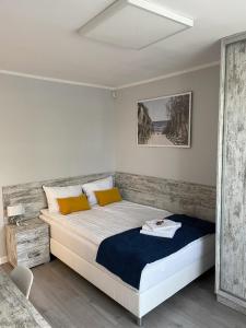 a bedroom with a large bed with yellow pillows at Willa Atlantis in Mielno