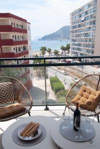 einen Tisch mit 2 Stühlen und eine Flasche Wein in der Unterkunft Apartamento con vistas al mar en la playa del Arenal-Bol de Calpe - Ref A016 AVANOA PREMIUM RENTALS in Calpe
