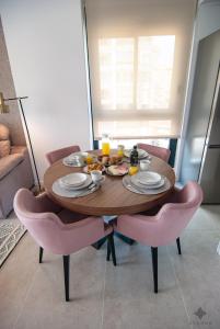 tavolo da pranzo con sedie rosa intorno di Apartamento con vistas al mar en la playa del Arenal-Bol de Calpe - Ref A016 AVANOA PREMIUM RENTALS a Calpe