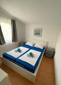 a bedroom with a bed with blue and white sheets at Apartments LucMar in Vir
