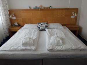 a bed with white sheets and towels on it at Apartmán C311 in Frymburk