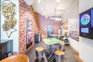 a ping pong table in a room with a brick wall at Flying Club in Tainan