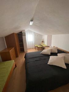 a bedroom with a black bed and a table at Apartmani Biserka in Punat