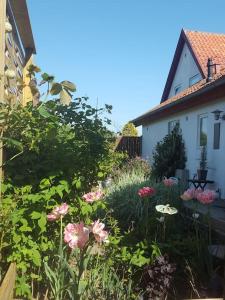 un jardín con flores rosas frente a una casa en The Loft. Studio-apartment in old farmhouse, en Hundested