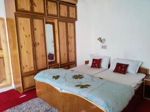 a bedroom with two beds and wooden cabinets at Yountan guest house in Leh