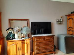 a room with a dresser and a mirror and a dresser with a television at la chambre de CLEO in Cannes