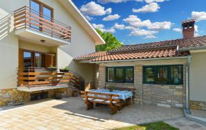 a patio of a house with a table and a balcony at House Marta 2157 in Žminj
