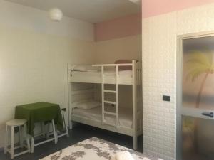 a bedroom with a bunk bed and a chair at Orange Villa Hotel in Tirana