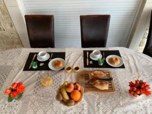 a table with a plate of bread and fruit on it at Chambres La Vieille Source in Saint-Martin-dʼArdèche
