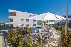 a patio with a table and chairs and an umbrella at Villa Poseidon Rova by EL-PI TOURS in Malinska