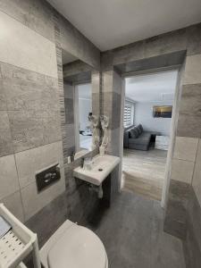 a bathroom with a sink and a toilet and a living room at Willa Atlantis in Mielno +129 photos