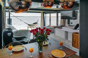 a table with a vase of flowers on a boat at Domki na wodzie - Grand HT Houseboats - with sauna, jacuzzi and massage chair in Mielno