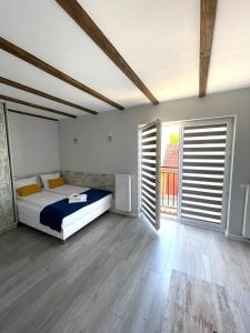 a bedroom with a bed and two large windows at Willa Atlantis in Mielno
