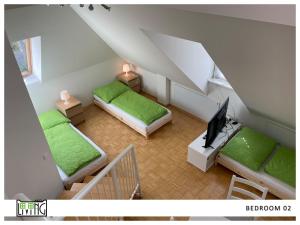 a attic room with two beds and a television at ACO Living - A chilli Overnight in Klagenfurt