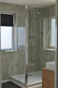 a shower with a glass door in a bathroom at Bed en Boats Zijlmans in Drimmelen