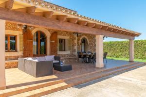 un patio esterno con pergolato e tavolo di Sa Cumuna a Campos
