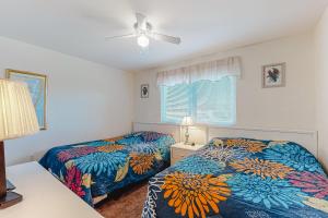 a bedroom with two beds and a ceiling fan at Raffles in Ocean City