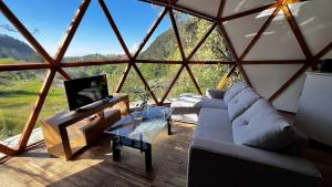 ein Wohnzimmer mit einem großen Fenster mit einem Sofa und einem TV in der Unterkunft DomoCantabria in Sobremazas