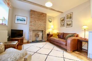 ein Wohnzimmer mit Couch und Kamin in der Unterkunft 14th century Rose cottage, Centre of Alfriston By Air Premier in Alfriston + 8 Fotos
