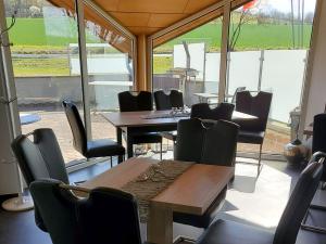 ein Esszimmer mit einem Tisch, Stühlen und einem Fenster in der Unterkunft Camping Oase Wahlhausen in Wahlhausen