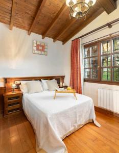 una camera da letto con un grande letto con un tavolo sopra di Casa en la Costa con wifi jardín y barbacoa a Llanes