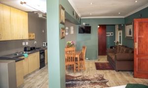 a kitchen and a living room with a couch at Big 5 Guest House Witbank in eMalahleni