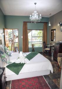 una camera da letto con un grande letto bianco e un lampadario a braccio di Big 5 Guest House Witbank a Witbank