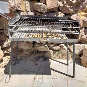 a grill sitting in front of a stone wall at Casa Sorianna in Montenegro de Cameros