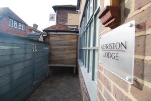 a sign on the side of a building with a entrance door at Alfriston Lodge By Air Premier in Alfriston