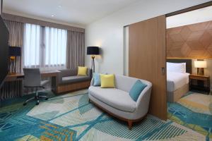 um quarto de hotel com um sofá, uma cama e uma secretária em Holiday Inn Cebu City, an IHG Hotel em Cebu