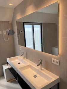 a bathroom with a sink and a large mirror at Keizershof Hotel Aalst in Aalst