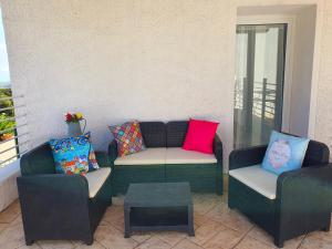 eine Terrasse mit 2 Stühlen, einem Sofa und einem Tisch in der Unterkunft JANAS Country House in Castelsardo