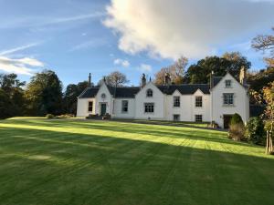 a large white house with a large yard at West Plean House in Stirling
