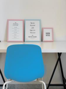 une table avec quatre photos et une chaise bleue dans l'établissement AllYouCanTrip - Porto, à Naples