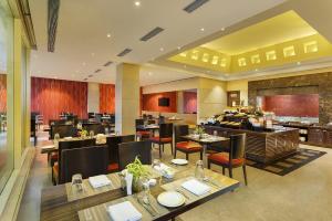 a dining room with tables and chairs in a restaurant at Hometel Roorkee in Roorkee